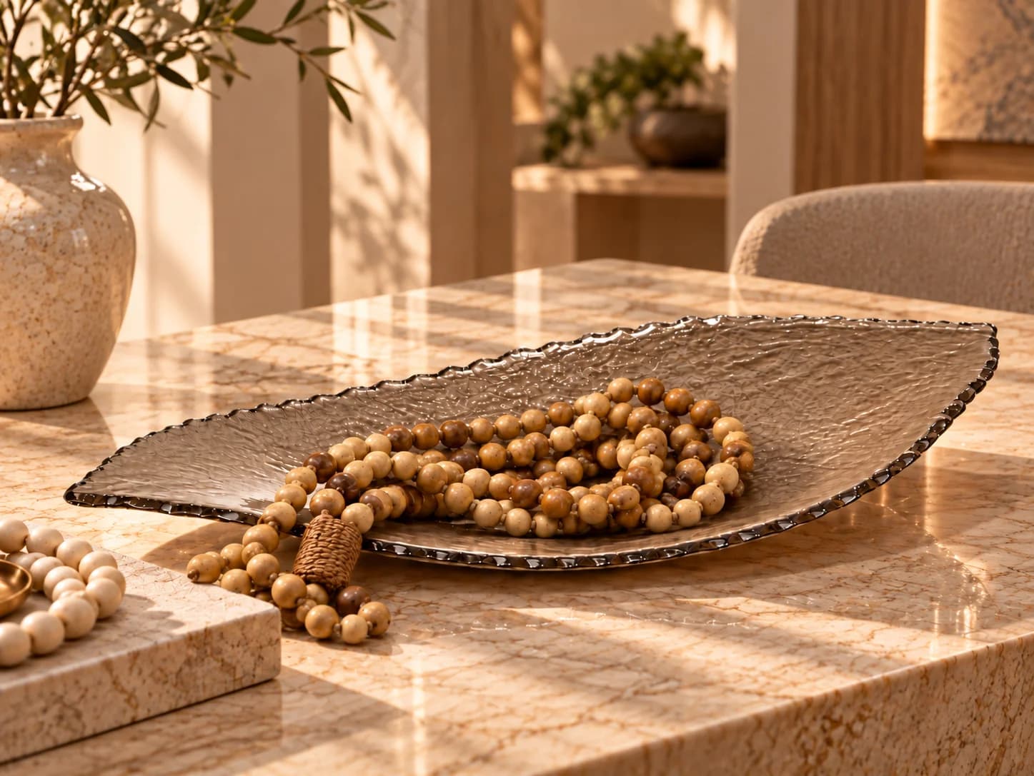 Peça em vidro fendi com contas de madeira sobre uma mesa de travertino